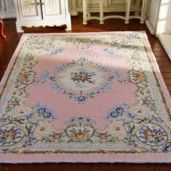 Victorian-style miniature rug with pink background and floral medallion