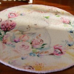 A round rug with a rabbit mother and baby surrounded by delicate flowers
