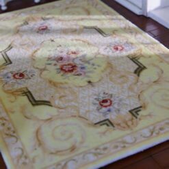 Light yellow Victorian miniature rug with floral medallion and intricate scroll designs.