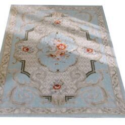 Victorian miniature rug with a floral medallion, soft blue background, and scrolls.