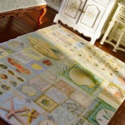 Miniature coastal rug with nautical motifs like lighthouses, starfish, and anchors.