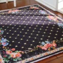 Floral miniature rug with a black background and rose border accents.