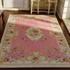 Victorian-style miniature rug in soft pink with floral accents and medallion design.