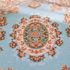 Miniature rug with a blue background and floral medallion, accented with scrollwork and floral details.