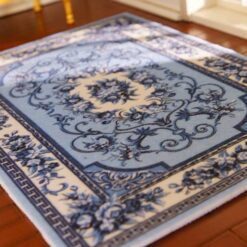 Victorian-inspired miniature rug in blue with floral scrollwork and a central medallion design.
