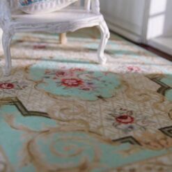Light blue Victorian miniature rug with a floral medallion and scrolling vine patterns.