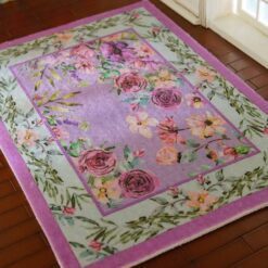 Lavender miniature rug with a pink floral border and purple blossoms with green leaves.