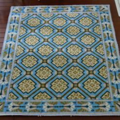Diamond pattern miniature dollhouse rug with gold medallions and blue background