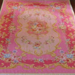 Victorian style miniature rug in pink with floral designs and golden scrollwork