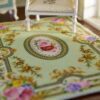 Floral rug with green background and roses surrounding an oval floral center
