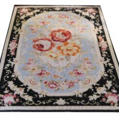 Persian-inspired miniature rug with a black background, floral bouquet center, and intricate floral border.