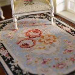 Persian-inspired miniature rug with a black background, floral bouquet center, and intricate floral border.
