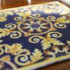 Miniature Aubusson square rug with scroll design in navy and gold.