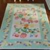 Pastel floral miniature rug featuring a colorful bouquet of flowers in pink, yellow, and green
