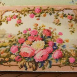 Miniature Aubusson tapestry showcasing roses cascading from a golden urn against a pastel backdrop.