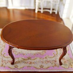 Miniature oval dining table with carved legs and mahogany finish.