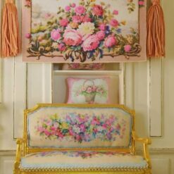 Miniature Aubusson tapestry showcasing roses cascading from a golden urn against a pastel backdrop.