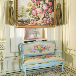 Ivory vase with colorful roses framed by a rich background, a miniature Aubusson tapestry.
