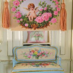 Cherub surrounded by pink roses and ornate golden details, a miniature Aubusson tapestry.