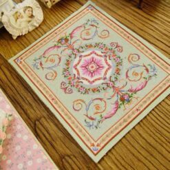 Miniature Rococo Victorian rug with scrolls, garlands, and central medallion.