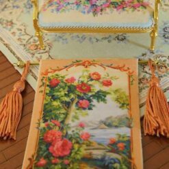 Tree with blooming roses beside a river framed with golden tones, a miniature Aubusson tapestry.