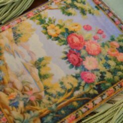 Blooming floral arch with vivid roses and a countryside backdrop in a miniature Aubusson tapestry.