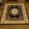 A Persian miniature rug with intricate floral design, perfect for dollhouses.