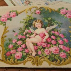 Winged cherub sitting among vibrant pink roses with golden details, a miniature Aubusson tapestry.
