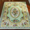 Green Victorian floral rug with gold and pink accents