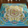 Blue Aubusson rug with floral patterns and scroll designs