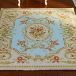 Miniature classic Victorian rug with floral pattern in blue and red.