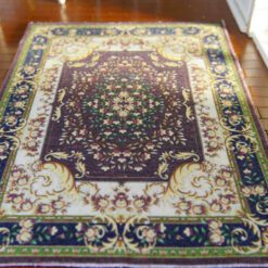 Modern Persian miniature rug with dark floral patterns and intricate borders in rich browns and golds