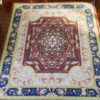 Light modern Persian miniature rug with floral patterns and soft borders in muted tones of pink and green