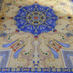 Paisley design miniature rug with deep blue and golden hues