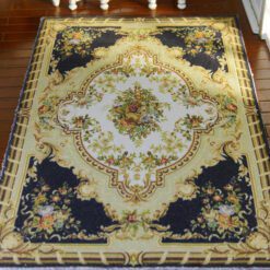 Black Aubusson rug with sunburst design in the center surrounded by floral details.