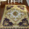 Classic Aubusson rug with purple and floral design, featuring a central medallion.