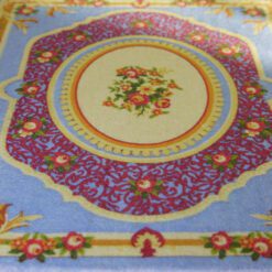 Victorian style miniature rug with intricate floral designs in blue, red, and yellow