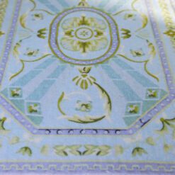 Light blue and green Aubusson rug with a central floral medallion and geometric patterns.
