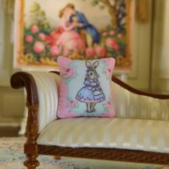 Miniature pillow featuring a bunny in a blue dress with pink roses