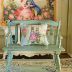 Miniature pillow with a rabbit couple in vintage attire surrounded by pink roses