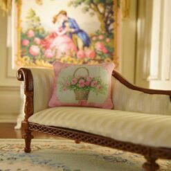 Miniature pillow featuring a basket of pink roses tied with a pink ribbon