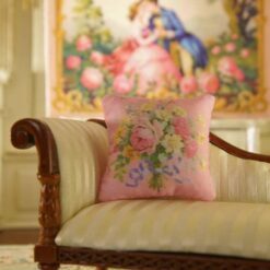 Miniature pillow with pink and yellow flowers tied with a blue ribbon