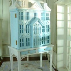 Blue townhouse-style miniature dollhouse with white table