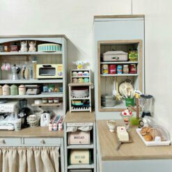 A double-sided corner cabinet kit for dollhouses, featuring open shelving and drawers.