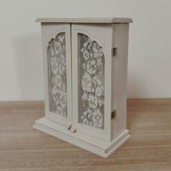 A vintage dollhouse wall cabinet with lace-acrylic windows.