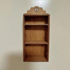 A miniature storage cabinet with shelves for dollhouses.