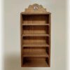 A miniature storage cabinet with shelves for dollhouses.