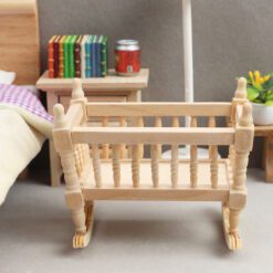 Miniature wooden rocking cradle for dollhouse nursery.