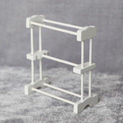Miniature white towel rack made from wood and bamboo for dollhouse bathrooms.
