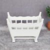 White miniature rocking cradle, ideal for nursery dollhouses.